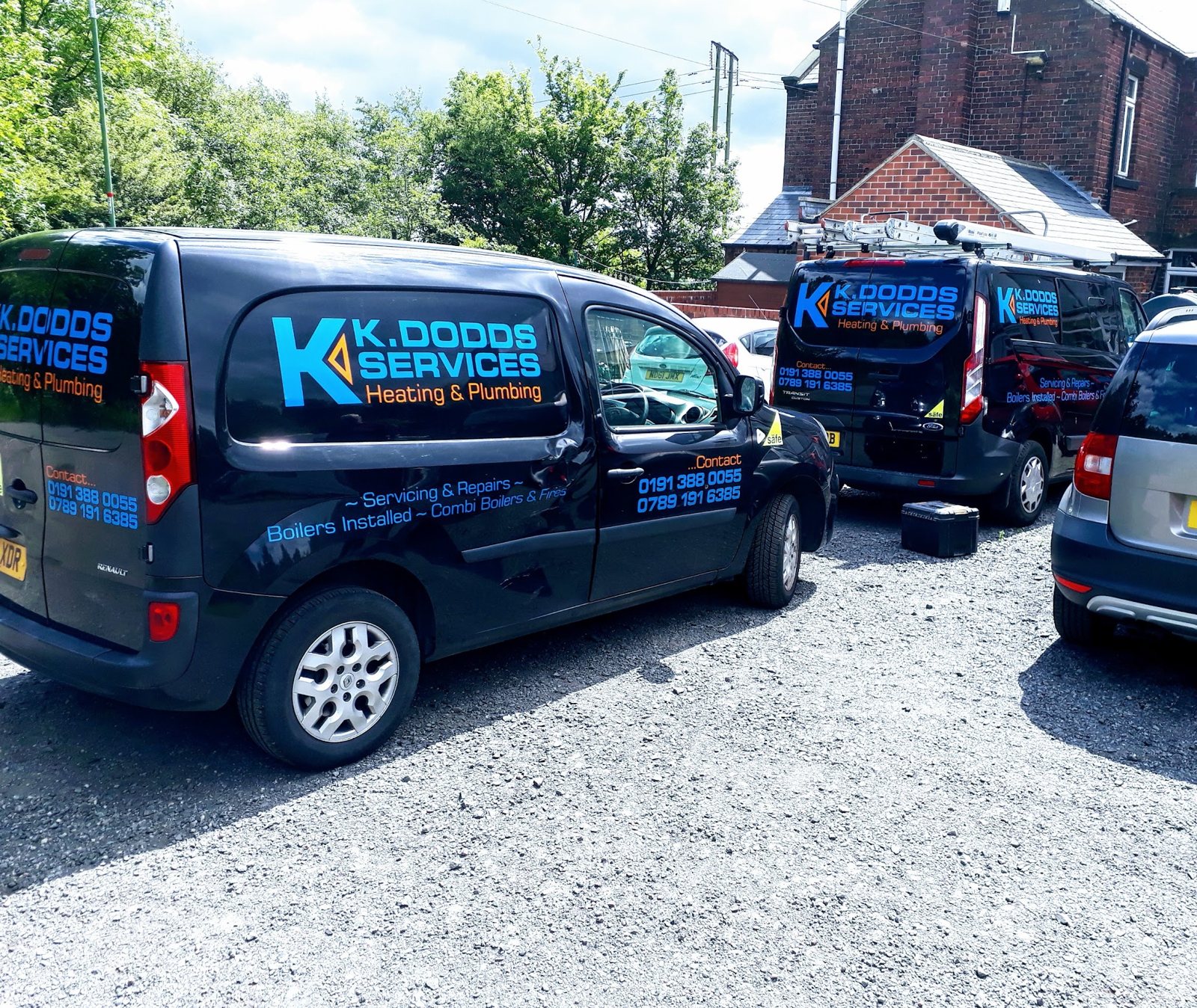 Two K Dodds Services vans in black livery with the blue K logo
