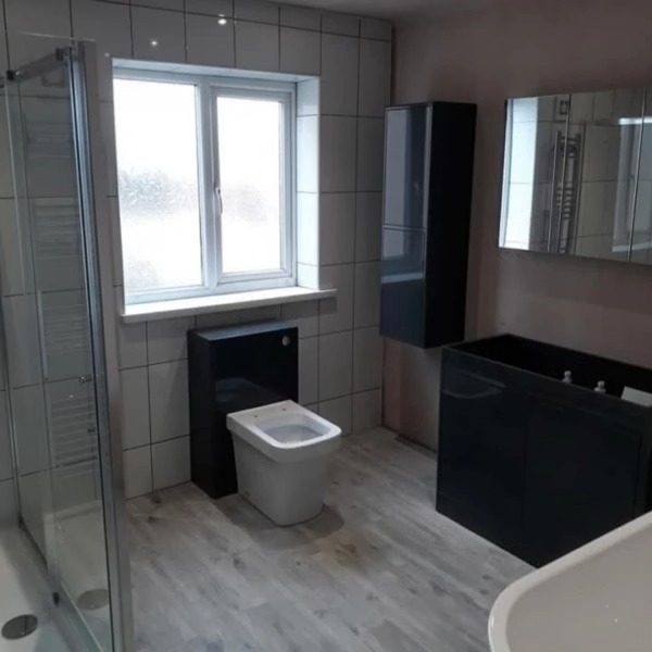Bathroom with a glass shower screen, heated towel rail and back-to-wall toilet