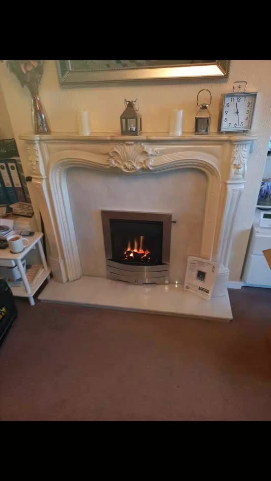 A gas fire fitted into a white surround, lit
