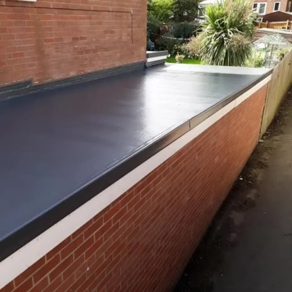 A finished grey flat roof on a brick extension